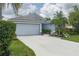 Charming single-Gathering home with a gray garage, complemented by lush landscaping and a welcoming driveway at 5209 Lansdowne Way, Palmetto, FL 34221