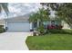 Charming single-story home with a well-manicured lawn, lush landscaping, and a two-car garage at 5209 Lansdowne Way, Palmetto, FL 34221