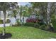 Beautifully landscaped front yard featuring vibrant flowers, lush greenery, and mature trees, enhancing curb appeal at 5209 Lansdowne Way, Palmetto, FL 34221