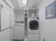 Bright laundry room equipped with modern washer and dryer, built-in shelving, and storage space at 5209 Lansdowne Way, Palmetto, FL 34221