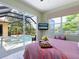 Bedroom with sliding door to patio, pool view, and television over looking the pink bed at 521 Habitat Blvd, Osprey, FL 34229