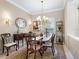 Formal dining room features a classic chandelier, elegant furnishings, and a decorative mirror creating a refined ambiance at 521 Habitat Blvd, Osprey, FL 34229