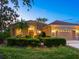 Inviting home exterior featuring a well-manicured lawn, mature landscaping, and a tiled roof at 521 Habitat Blvd, Osprey, FL 34229
