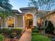Home exterior featuring a landscaped yard and a red brick walkway leading to the front entrance at 521 Habitat Blvd, Osprey, FL 34229
