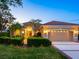 Inviting home exterior featuring a well-manicured lawn, mature landscaping, and a tiled roof at 521 Habitat Blvd, Osprey, FL 34229