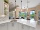 Kitchen showcases a quartz countertop with sink and a view of the outdoor pool area with a screened enclosure at 521 Habitat Blvd, Osprey, FL 34229
