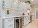 Bright kitchen with white cabinets, wine fridge, stylish backsplash, and modern appliances offers a sophisticated cooking space at 521 Habitat Blvd, Osprey, FL 34229