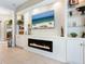 Stylish living room featuring a modern electric fireplace, built-in shelves, and a large flatscreen TV at 521 Habitat Blvd, Osprey, FL 34229