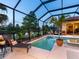 Inviting screened-in pool and spa, nestled beside a serene lake setting at 521 Habitat Blvd, Osprey, FL 34229