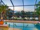 Sparkling pool with spa and lake views, surrounded by lush landscaping at 521 Habitat Blvd, Osprey, FL 34229