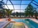 Screened-in pool and spa area overlooking a tranquil lake at 521 Habitat Blvd, Osprey, FL 34229