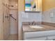 Modern bathroom featuring a granite countertop vanity and a tiled walk-in shower with grab bars for accessibility at 5705 9Th Ave Dr W, Bradenton, FL 34209