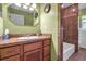 Cozy bathroom with a wooden vanity with sink, medicine cabinet and a tiled shower with tub at 5705 9Th Ave Dr W, Bradenton, FL 34209