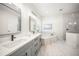 Elegant bathroom with double vanity, soaking tub with marble surround, and glass-enclosed shower at 6152 Lungo Lago Dr, Sarasota, FL 34241