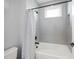 Bright bathroom featuring a tub with a shower and modern grey tiling at 6152 Lungo Lago Dr, Sarasota, FL 34241