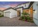 Charming two-story home with a well-manicured lawn, palm trees, and a paved driveway, offering great curb appeal at 6152 Lungo Lago Dr, Sarasota, FL 34241