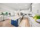 Open-concept kitchen with a large center island with marble countertop, stainless steel appliances, and wood flooring at 6152 Lungo Lago Dr, Sarasota, FL 34241