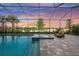 Gorgeous pool and spa with screened-in lanai, complemented by views of the serene lake at sunset at 6152 Lungo Lago Dr, Sarasota, FL 34241