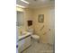 A well-lit bathroom featuring a toilet, sink, grab bars, and a neutral color palette at 6357 Partridge Ave, Englewood, FL 34224