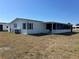 Single-story home with white siding, black shutters, screen room, and well-maintained lawn at 6357 Partridge Ave, Englewood, FL 34224