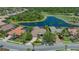 Aerial view of a home with a clay tile roof, pool, lake, and golf course views at 6633 The Masters Ave, Lakewood Ranch, FL 34202