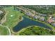 Stunning aerial view of home features backyard pool, beautiful lake view, and golf course at 6633 The Masters Ave, Lakewood Ranch, FL 34202