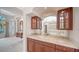 Stylish wet bar with wood cabinets, a marble countertop, and a mirrored backsplash in an elegant setting at 6633 The Masters Ave, Lakewood Ranch, FL 34202