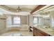 A detailed bathroom boasts marble floors, patterned wallpaper, a large tub, and a shower at 6633 The Masters Ave, Lakewood Ranch, FL 34202