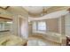 An elegant bathroom features a large tub, walk-in shower, and patterned wallpaper at 6633 The Masters Ave, Lakewood Ranch, FL 34202