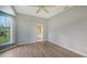 This bedroom features light blue paint, wood-look floors, a ceiling fan, and windows with natural light at 6633 The Masters Ave, Lakewood Ranch, FL 34202