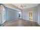 This bedroom features light blue paint, wood-look floors, a ceiling fan, and windows with natural light at 6633 The Masters Ave, Lakewood Ranch, FL 34202