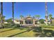 Beautiful clubhouse exterior with lush landscaping, palm trees, and a well-maintained lawn at 6633 The Masters Ave, Lakewood Ranch, FL 34202