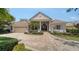 Charming home with a clay tile roof, arched entryway, brick driveway, and attached garage at 6633 The Masters Ave, Lakewood Ranch, FL 34202