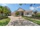 Inviting single-story home with a red tile roof, arched entryway, and lush landscaping at 6633 The Masters Ave, Lakewood Ranch, FL 34202