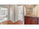 A view of the hallway with wood floors leading to the bathroom and other rooms at 6633 The Masters Ave, Lakewood Ranch, FL 34202
