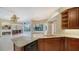Well-equipped kitchen with stone countertops, wood cabinets, and views into the adjacent living room at 6633 The Masters Ave, Lakewood Ranch, FL 34202