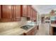 Gourmet kitchen featuring stone countertops, gas range and seamless flow to the living space with a fireplace at 6633 The Masters Ave, Lakewood Ranch, FL 34202