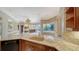 Gourmet kitchen featuring stone countertops, wooden cabinetry, and a seamless flow into the expansive living area at 6633 The Masters Ave, Lakewood Ranch, FL 34202