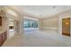 Spacious living room with decorative molding, carpet floors, and a view of the outdoor pool area at 6633 The Masters Ave, Lakewood Ranch, FL 34202