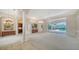 Spacious living room with neutral carpet, elegant columns, and a view of the screened-in pool at 6633 The Masters Ave, Lakewood Ranch, FL 34202