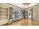 Bright living room with a large window overlooking a lake and built-in bookshelves at 6633 The Masters Ave, Lakewood Ranch, FL 34202
