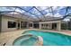Inviting screened pool with attached spa and outdoor kitchen area, ideal for entertaining at 6633 The Masters Ave, Lakewood Ranch, FL 34202