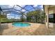 Screened-in pool and spa area with a brick tile patio and garden views at 6633 The Masters Ave, Lakewood Ranch, FL 34202