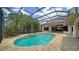 Beautiful screened pool with a spa and patio area, surrounded by lush landscaping at 6633 The Masters Ave, Lakewood Ranch, FL 34202