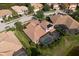 Aerial view showcases a home with solar panels and a screened pool in a neighborhood at 6951 Scrub Jay Dr, Sarasota, FL 34241