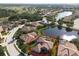 Aerial view of a home with a pool surrounded by lush landscaping and serene pond at 6951 Scrub Jay Dr, Sarasota, FL 34241