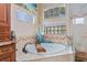 Close up of the garden tub in the bathroom with tiled tub surround and glass block window at 6951 Scrub Jay Dr, Sarasota, FL 34241