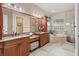Spacious bathroom featuring double vanity sinks, a soaking tub, a separate shower, and custom cabinets at 6951 Scrub Jay Dr, Sarasota, FL 34241