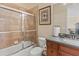 Bathroom featuring a glass shower door, wood cabinet, and neutral tile at 6951 Scrub Jay Dr, Sarasota, FL 34241