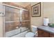 Bathroom featuring a glass shower door, wood cabinet, and neutral tile at 6951 Scrub Jay Dr, Sarasota, FL 34241
